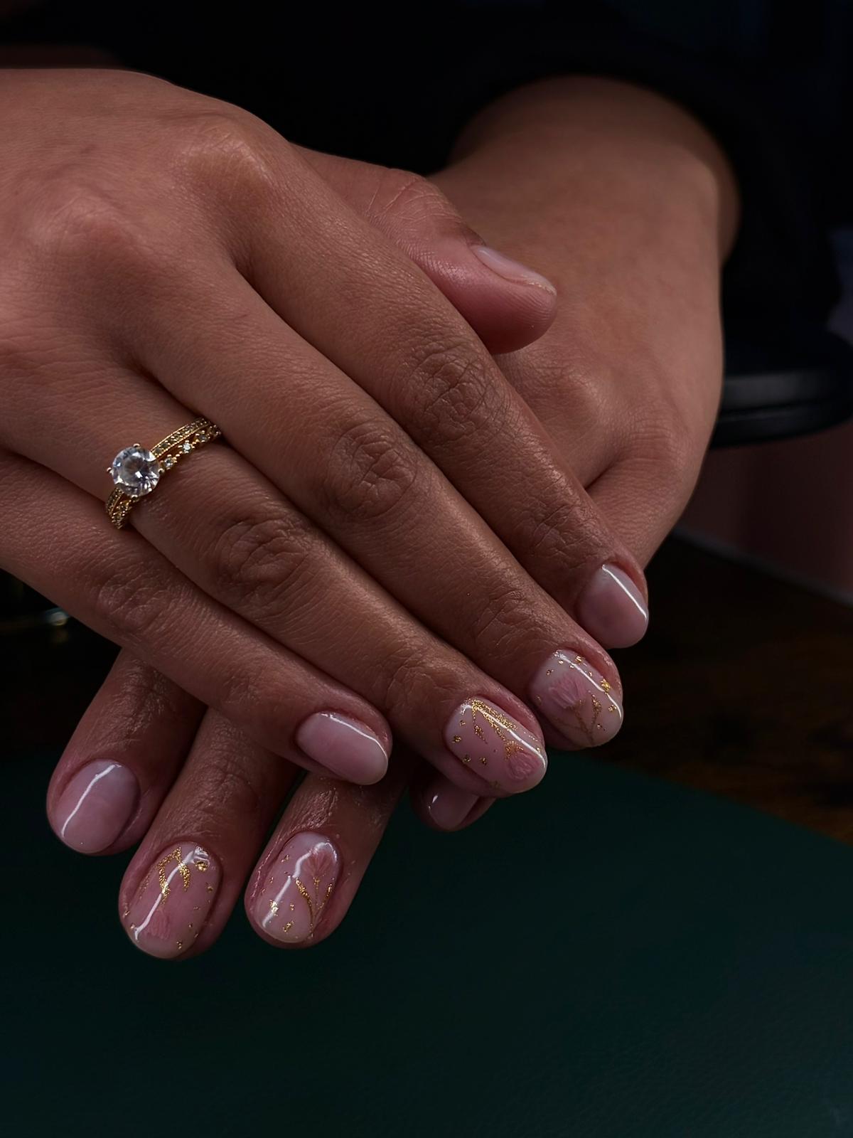 Manicure em gel nude com detalhes dourados